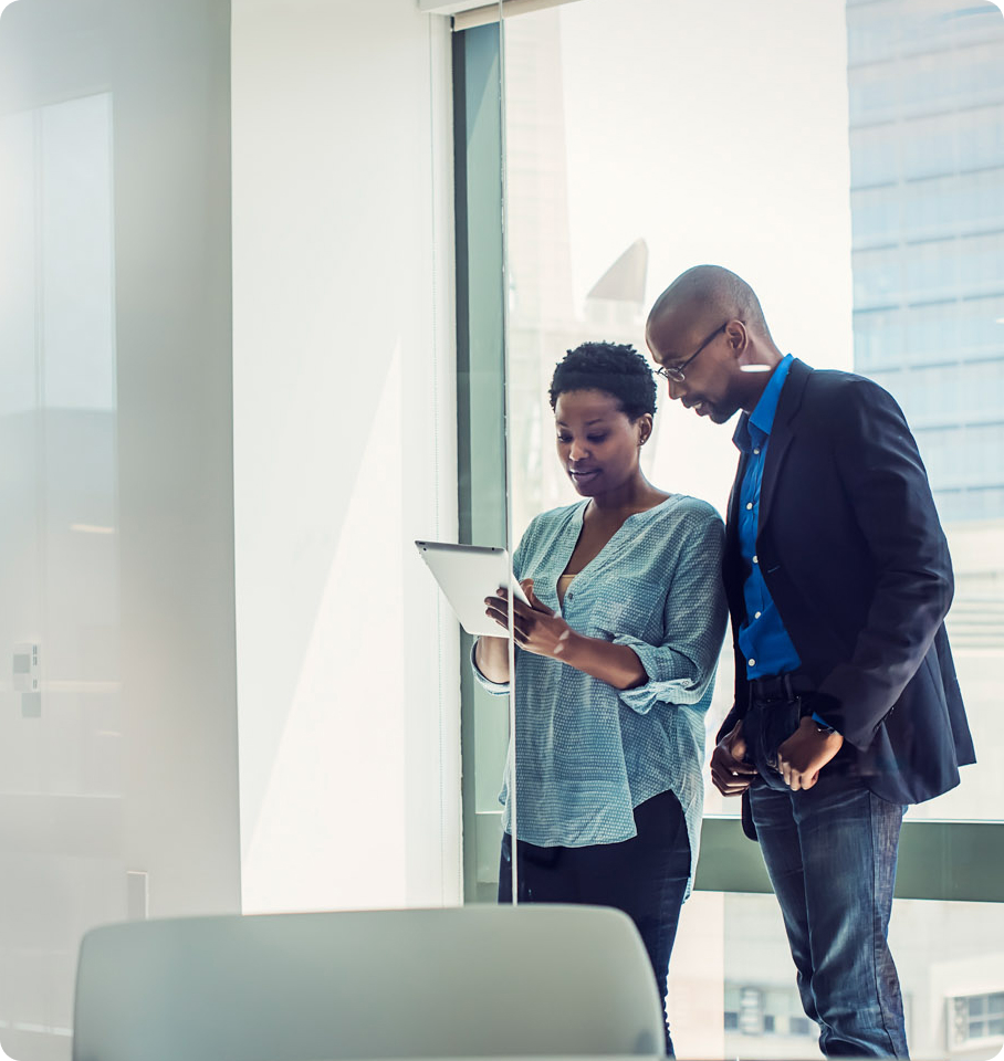 Image of male and female healthcare professionals in an office looking at a tablet screen.