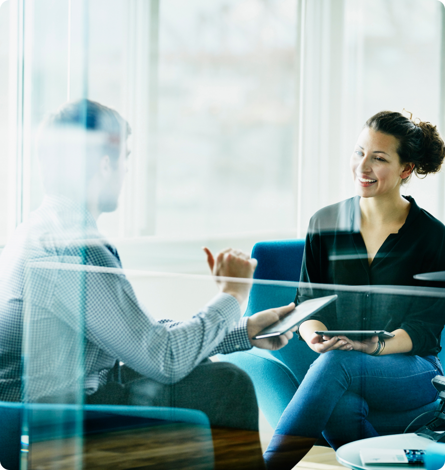 Image of a male and female healthcare professionals sitting in an office having a conversation.