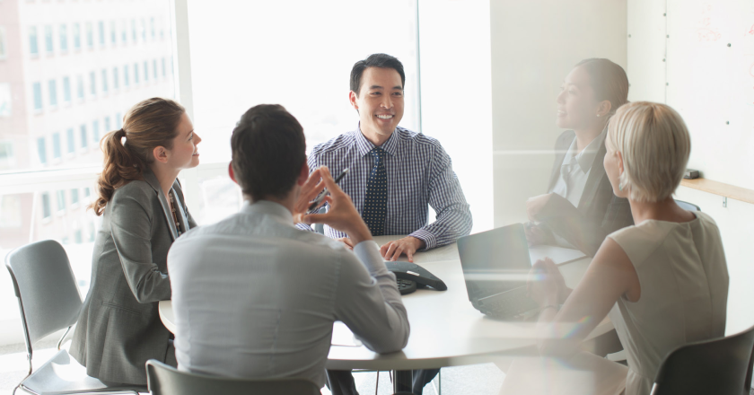 Image of diverse group of healthcare professionals gathered around an office table.