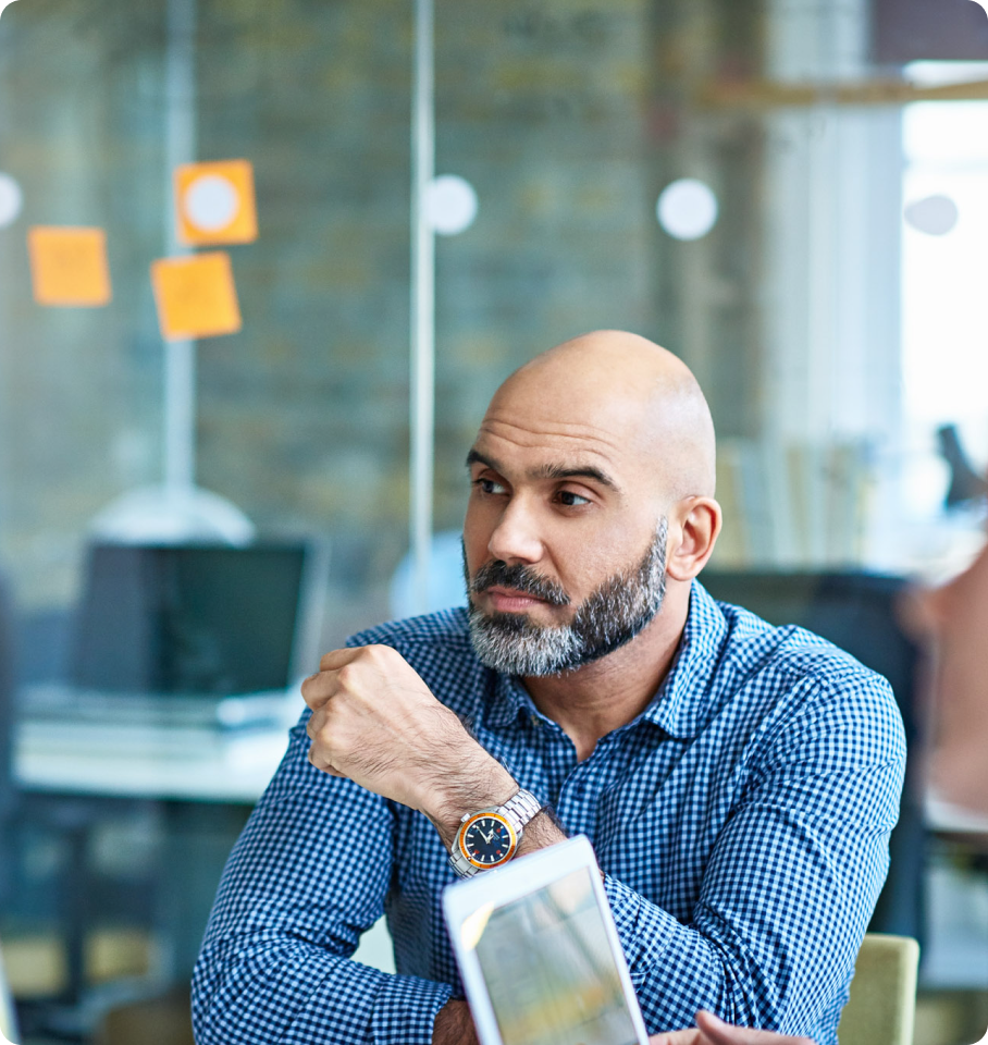 Male healthcare professional sitting in office listening to coworker discuss Medicare